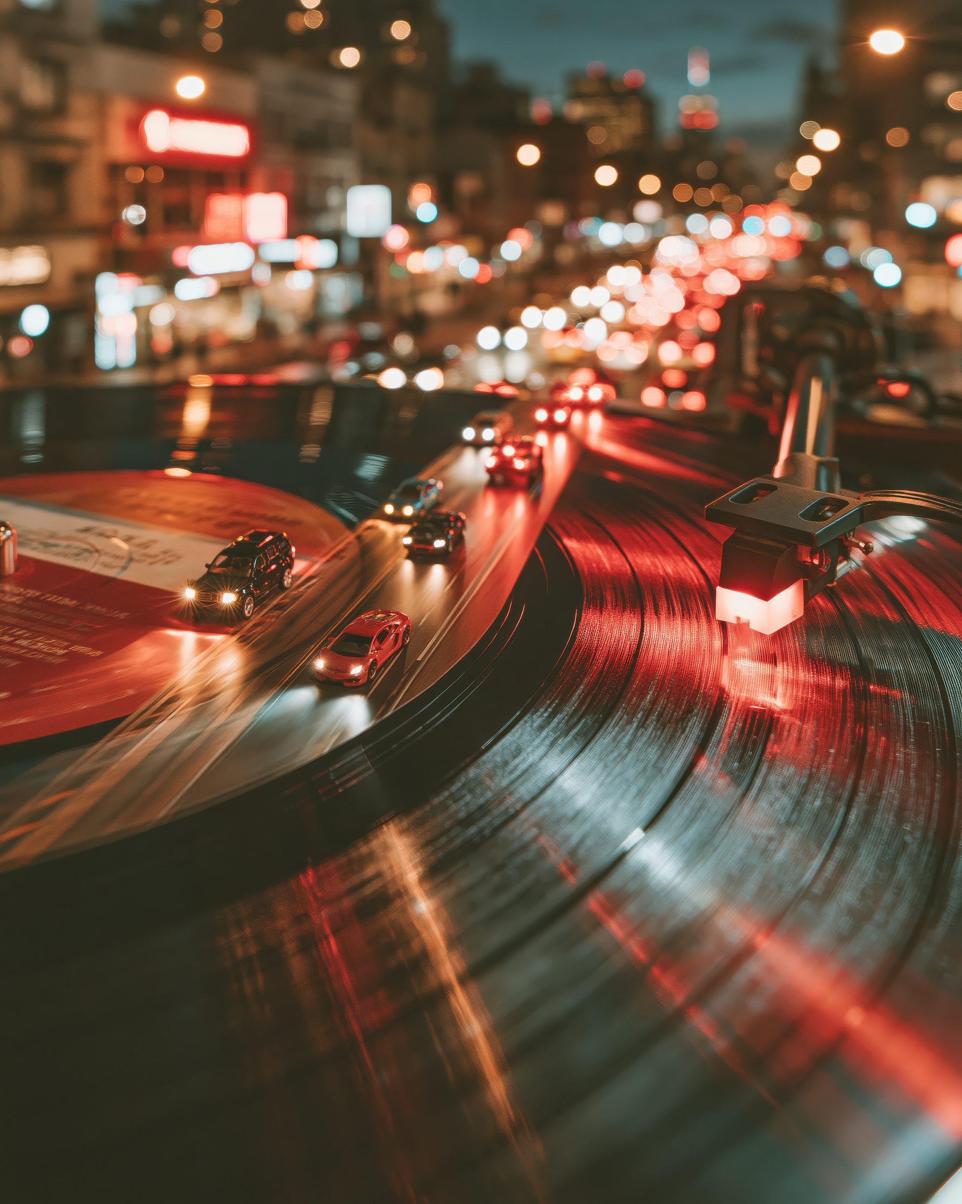 Rille: Autos folgen der Rille einer Schallplatte, als hätte die Nacht ihren Verkehr in Musik verwandelt.