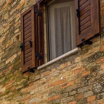 Vorher: Fenster mit offenen Holzläden und weißem Vorhang bei Tageslicht